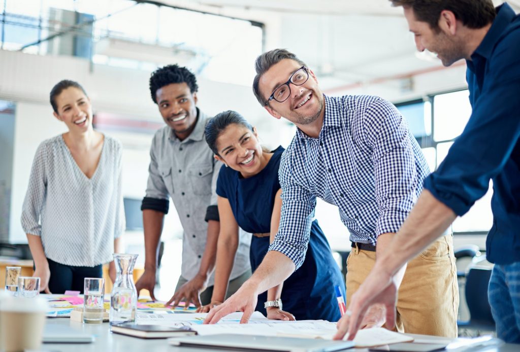 Group of diverse professionals listening positively to a team member describe his idea